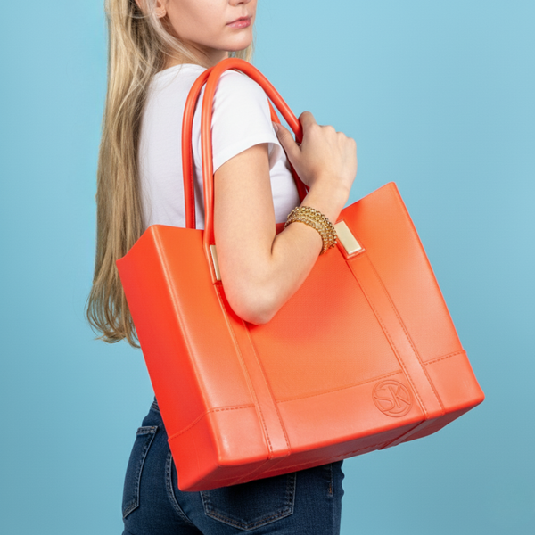Woman holding Cali tote bag against a blue background